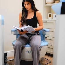 Client reading while seated on pelvic chair